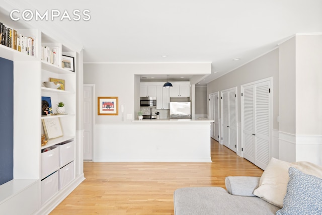 living room featuring light wood-style flooring, recessed lighting, and crown molding