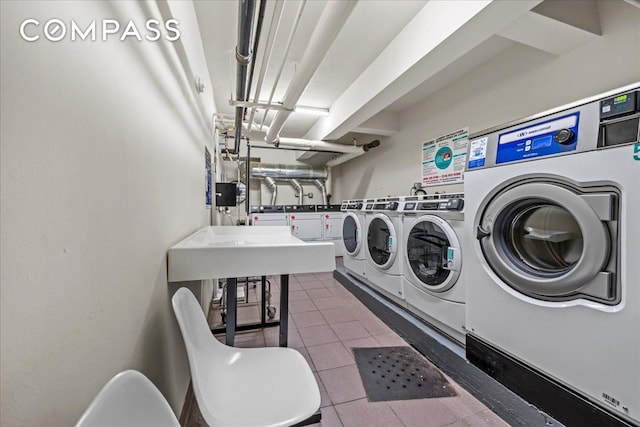 community laundry room with washer and clothes dryer and tile patterned flooring
