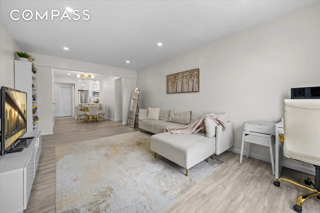living area with light wood-style floors, a chandelier, recessed lighting, and baseboards