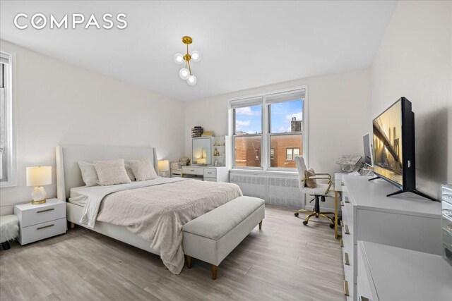 bedroom featuring light wood finished floors and radiator