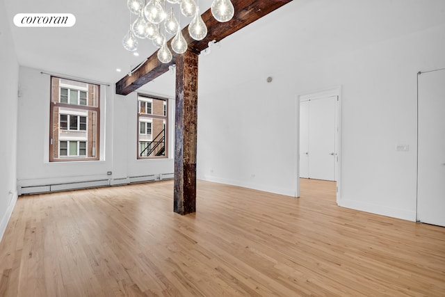 124 W 24th St Unit 4B, New York City, NY 10011 - unfurnished living room with light wood-type flooring, baseboard heating, a chandelier, and beamed ceiling