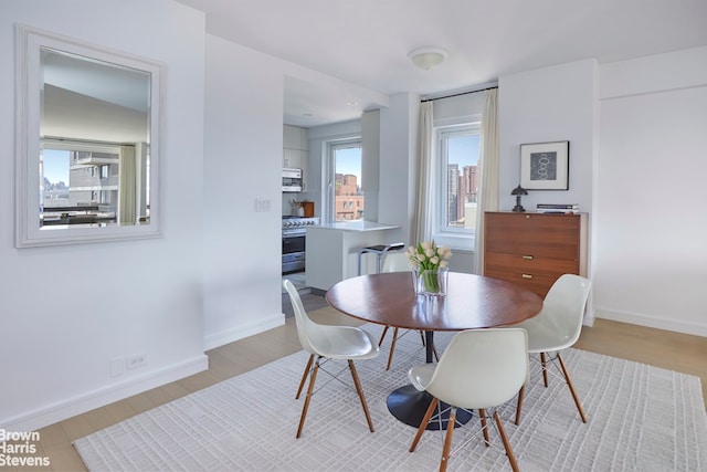 dining room with light wood finished floors and baseboards