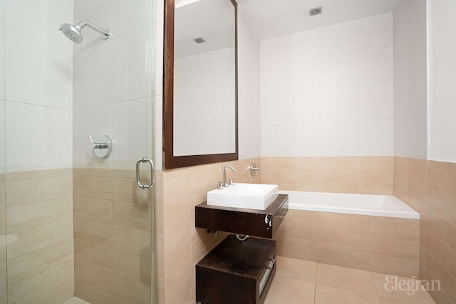 full bathroom featuring a shower stall, tile walls, vanity, tile patterned flooring, and a garden tub