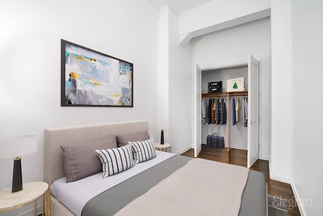 bedroom with dark wood-style floors, a closet, and baseboards