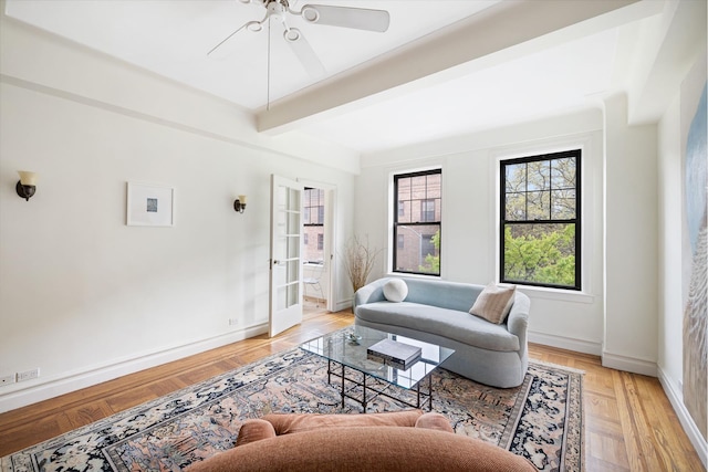 living room with plenty of natural light, beamed ceiling, baseboards, and ceiling fan