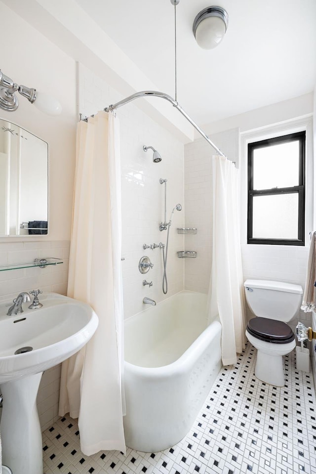 full bathroom with tile walls, toilet, shower / bath combo with shower curtain, and tile patterned flooring
