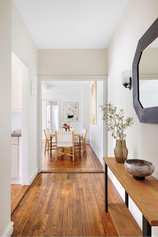 corridor with hardwood / wood-style flooring and baseboards