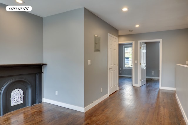 unfurnished living room with baseboards, dark wood-type flooring, recessed lighting, and electric panel