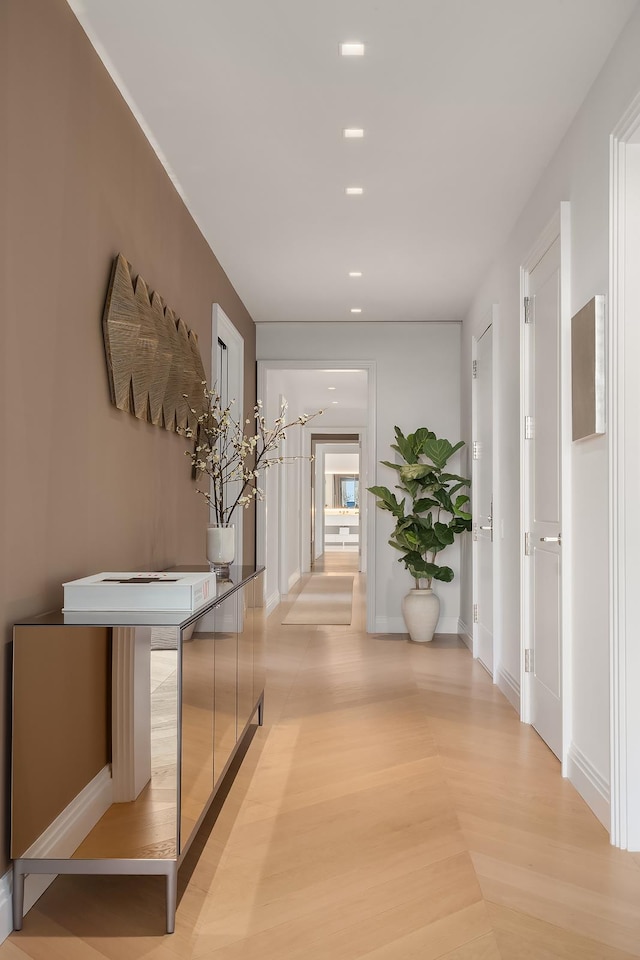 hallway with light wood-type flooring, baseboards, and recessed lighting