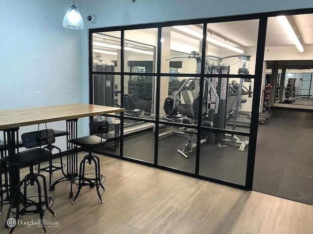 exercise room with wood finished floors and ceiling fan