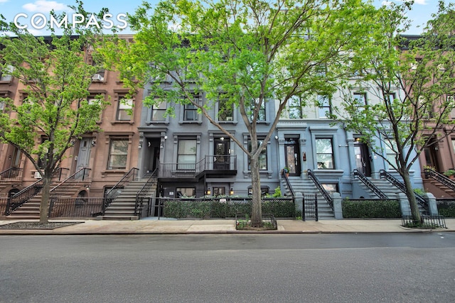 townhome / multi-family property with a fenced front yard and stairs