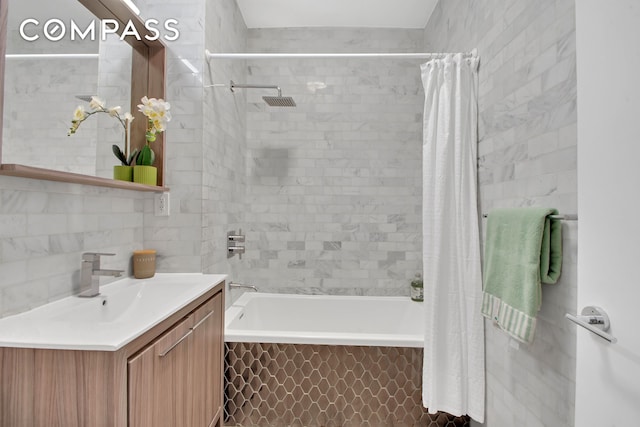 full bathroom featuring tiled shower / bath, tile walls, and vanity