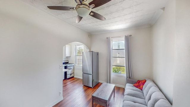 25A Roosevelt Place, New York City, NY 11233 - sitting room with arched walkways, dark wood finished floors, an ornate ceiling, ceiling fan, and ornamental molding