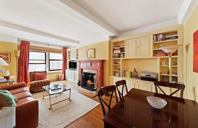 205 E 78th St Unit 12J, New York City, NY 10021 - living area featuring a tile fireplace, light wood finished floors, beamed ceiling, and built in features