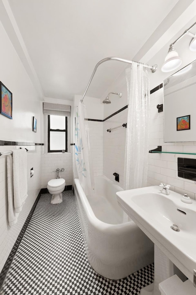 205 E 78th St Unit 12J, New York City, NY 10021 - full bath with tile walls, shower / tub combo with curtain, toilet, and wainscoting