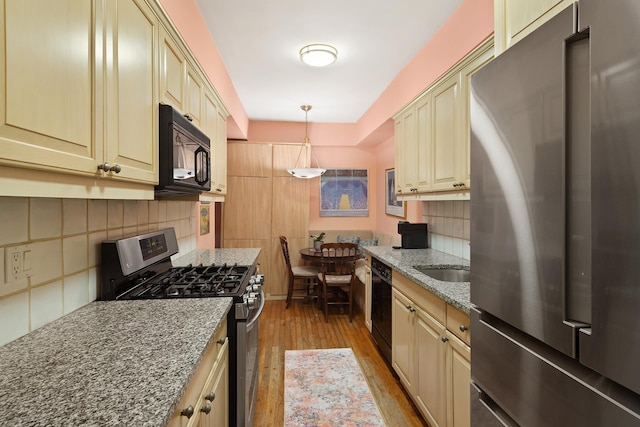 205 E 78th St Unit 12J, New York City, NY 10021 - kitchen featuring black appliances, cream cabinets, and backsplash