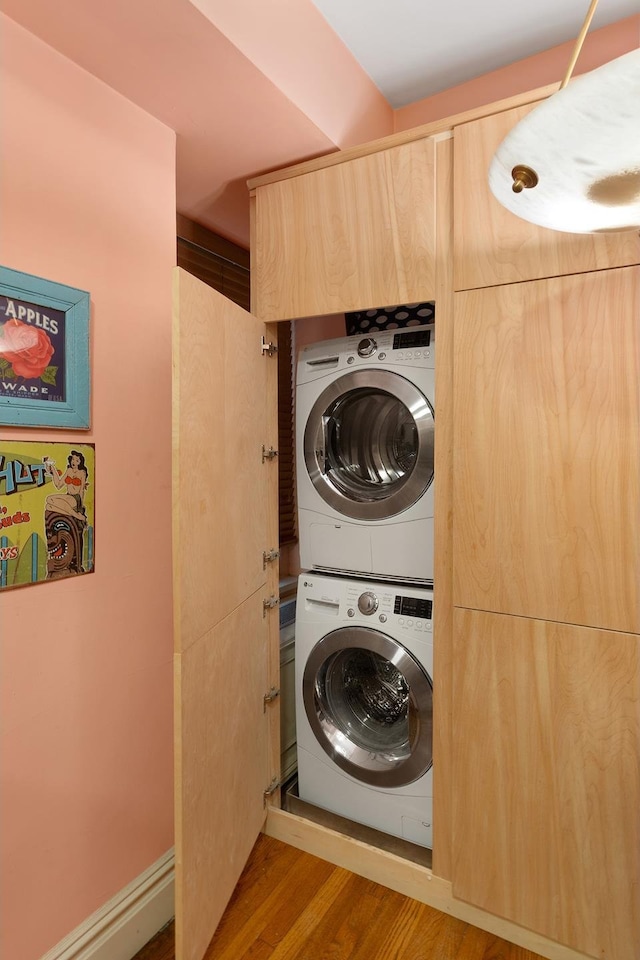 205 E 78th St Unit 12J, New York City, NY 10021 - laundry area featuring estacked washer and dryer and wood finished floors