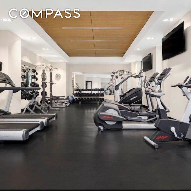 workout area featuring a raised ceiling and wood ceiling