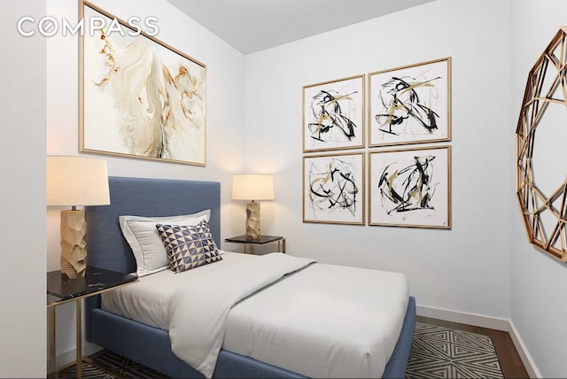 bedroom with wood finished floors and baseboards