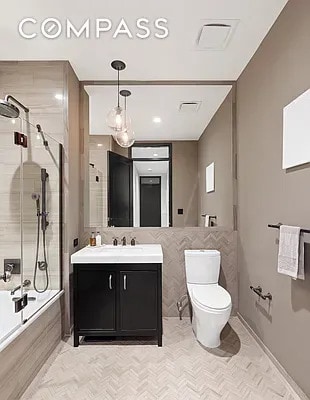 full bath featuring combined bath / shower with glass door, toilet, and vanity