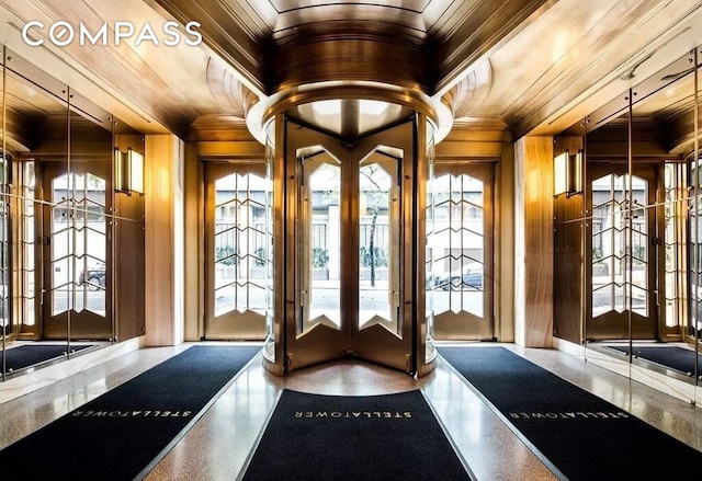 doorway with crown molding, wooden ceiling, wooden walls, and french doors