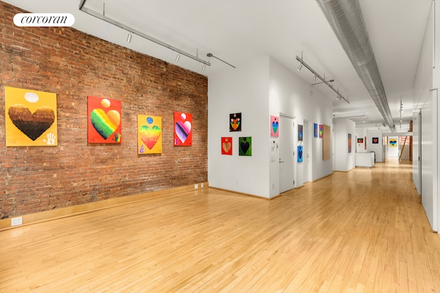 25 E 4th St Unit 2, New York City, NY 10003 - unfurnished room with light wood-style flooring, rail lighting, brick wall, and a towering ceiling