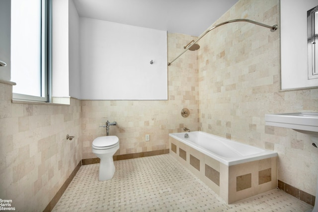 full bath featuring tile walls, toilet, and tiled shower / bath