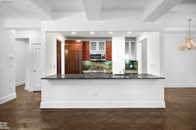 kitchen with stainless steel microwave, paneled fridge, recessed lighting, baseboards, and tasteful backsplash