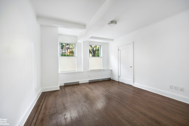 unfurnished room with wood finished floors, baseboards, and beamed ceiling