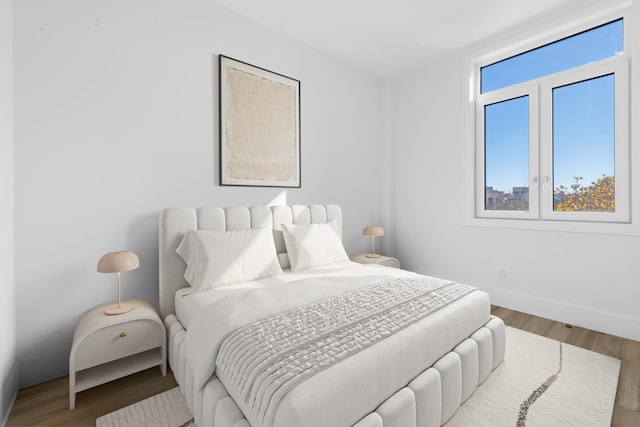 bedroom featuring wood finished floors and baseboards