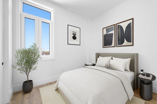 bedroom featuring wood finished floors and baseboards