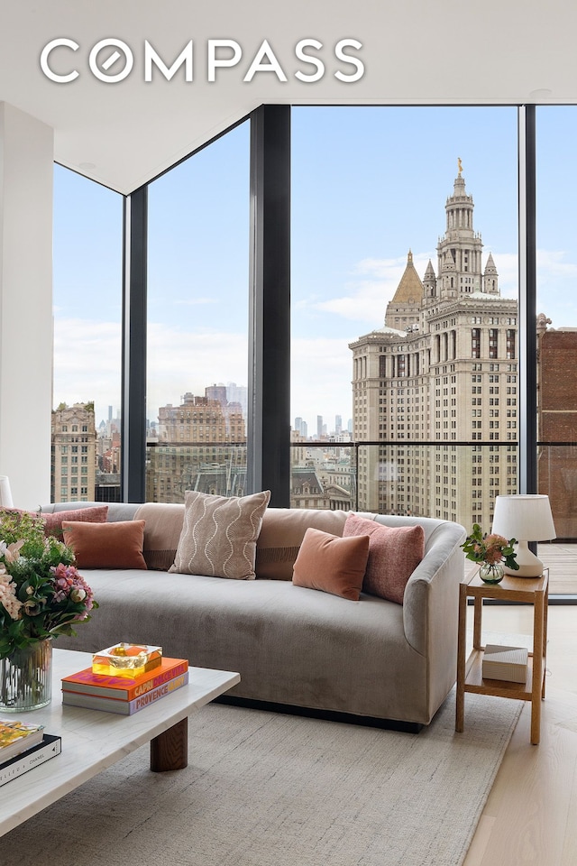 living room with a city view, expansive windows, and wood finished floors