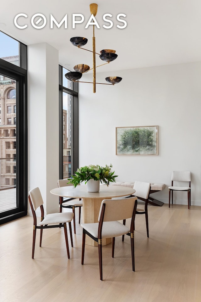 dining area with a wall of windows and light wood-style floors