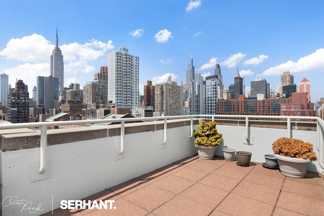 view of patio / terrace with a view of skyline and a balcony