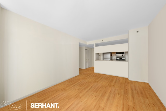 250 E 30th St Unit 8D, New York City, NY 10016 - unfurnished living room with light wood finished floors and baseboards