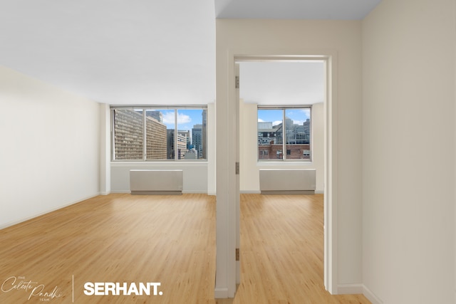 250 E 30th St Unit 8D, New York City, NY 10016 - unfurnished living room with light wood-type flooring, a city view, and baseboards