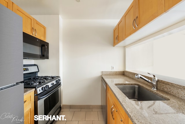 250 E 30th St Unit 8D, New York City, NY 10016 - kitchen featuring appliances with stainless steel finishes, a sink, light tile patterned floors, and light stone countertops
