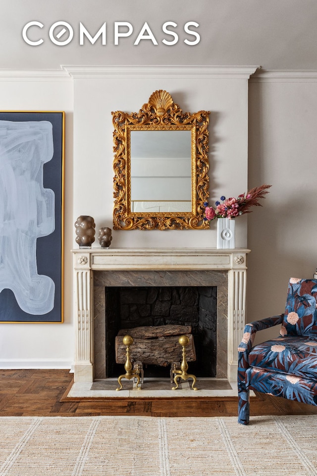 detailed view of a premium fireplace, ornamental molding, and baseboards
