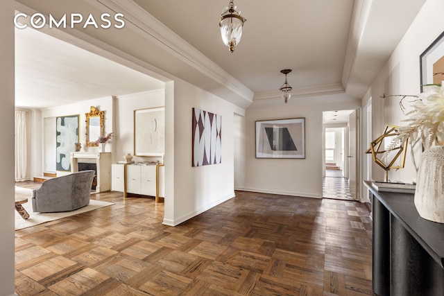 foyer entrance featuring baseboards, a fireplace, and crown molding