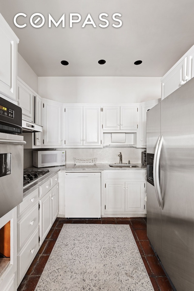 138 W 73rd St, New York City, NY 10023 - kitchen with appliances with stainless steel finishes, a sink, white cabinets, and decorative backsplash