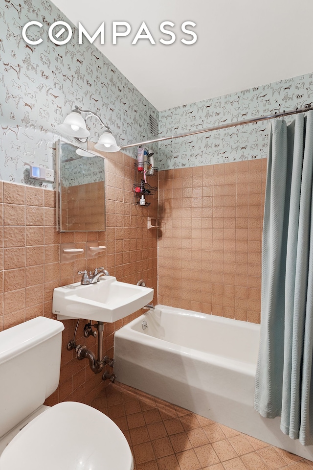 138 W 73rd St, New York City, NY 10023 - bathroom featuring shower / tub combo with curtain, a sink, toilet, tile walls, and wallpapered walls
