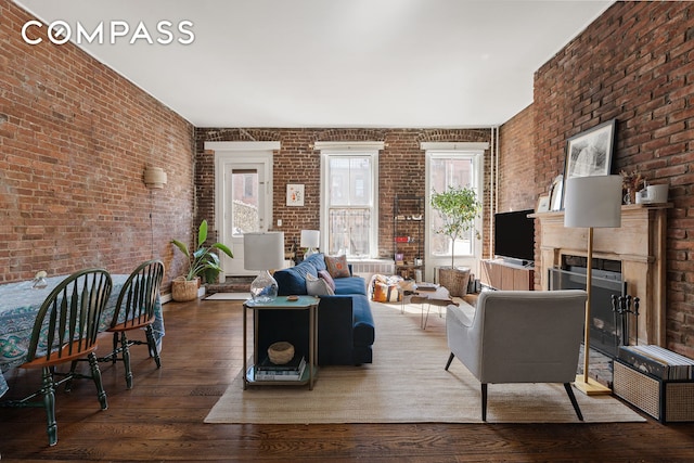 138 W 73rd St, New York City, NY 10023 - living area with brick wall, plenty of natural light, hardwood / wood-style floors, and a fireplace