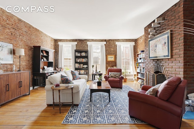 138 W 73rd St, New York City, NY 10023 - living room with brick wall, plenty of natural light, hardwood / wood-style floors, and a fireplace