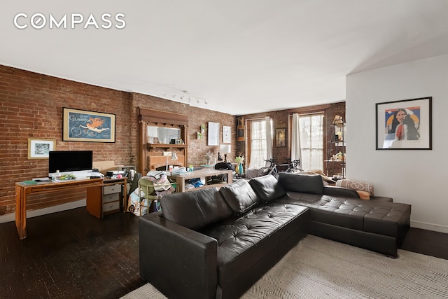 138 W 73rd St, New York City, NY 10023 - living room with wood-type flooring, baseboards, brick wall, and a desk