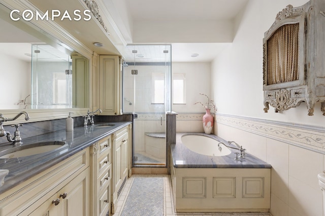 138 W 73rd St, New York City, NY 10023 - bathroom with a stall shower, a garden tub, a wainscoted wall, double vanity, and tile patterned floors