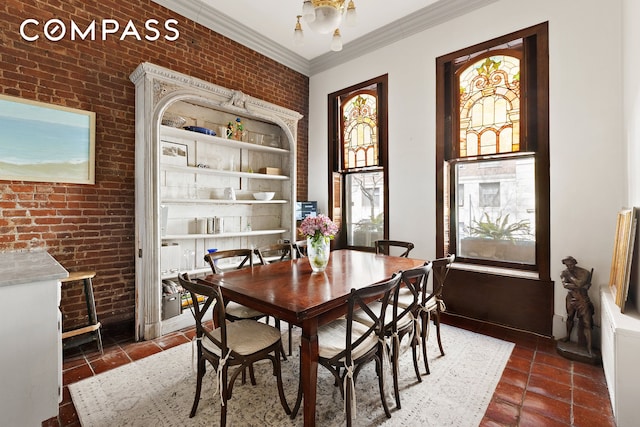 138 W 73rd St, New York City, NY 10023 - dining room featuring brick wall, crown molding, and dark tile patterned floors