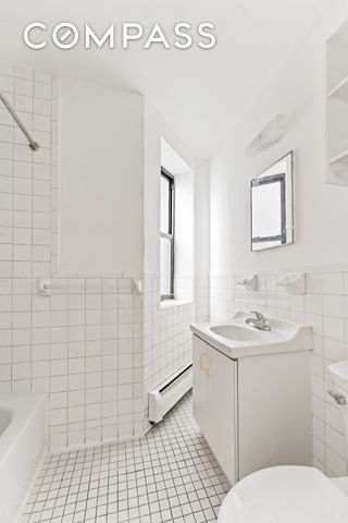full bath featuring tile walls, a baseboard heating unit, toilet, tile patterned floors, and vanity