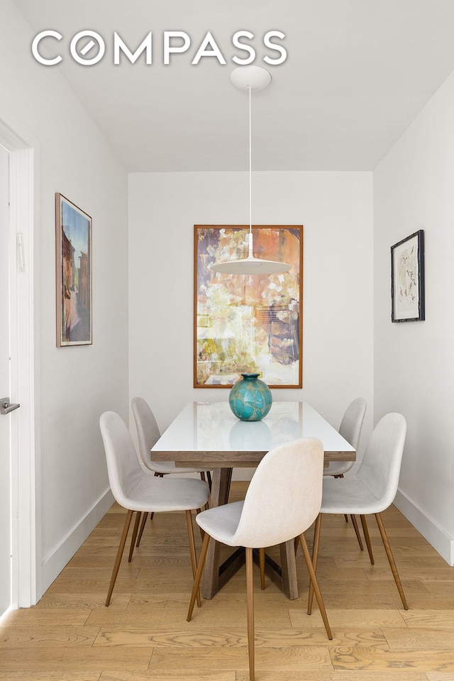 dining area with light wood-style flooring and baseboards