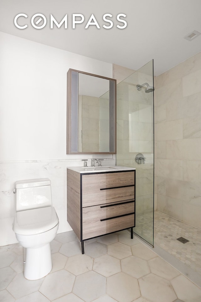 264 Webster Ave Unit 709, New York City, NY 11230 - full bathroom featuring vanity, tile walls, walk in shower, toilet, and tile patterned flooring