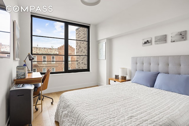 264 Webster Ave Unit 709, New York City, NY 11230 - bedroom with wood finished floors, baseboards, and an office area